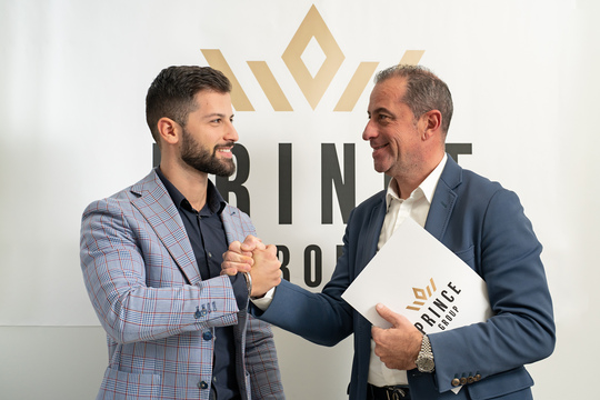 Consulenti Prince Group nella sede aziendale davanti al logo